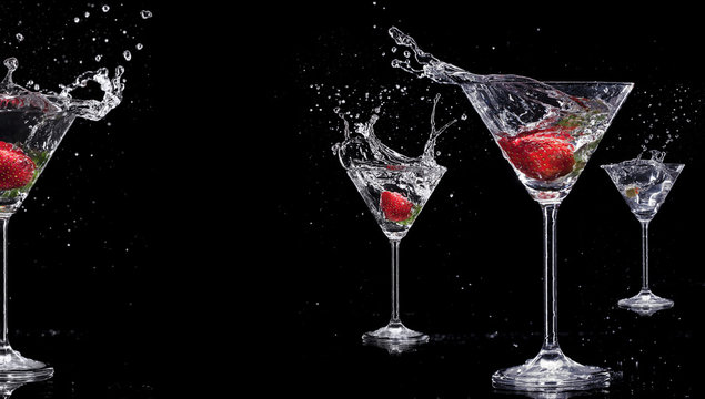 Martini drinks with splashes, isolated on black background