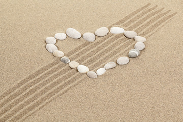 Fototapeta na wymiar handwritten heart on sand with seashell