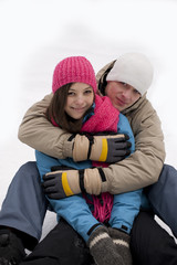 Winter couple sitting on the snow