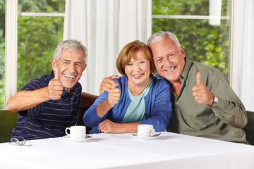 Senioren beim Kaffeetrinken halten Daumen hoch