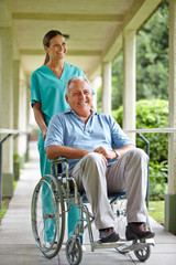 Senior im Rollstuhl mit Krankenpflegerin