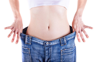Slim woman shows her weight loss by wearing an jeans