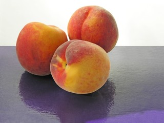 Fototapeta na wymiar gold and red peaches on lila plate