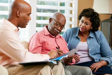 Financial Advisor Talking To Senior Couple At Home