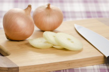 Onions and onion slices on cuttingboard.