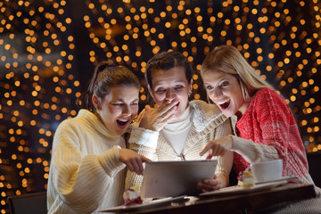 happy girls group  looking at a pc tablet