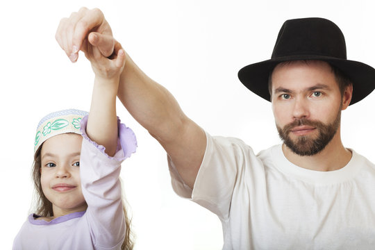 Man in Jewish hat and girl in skullcap.