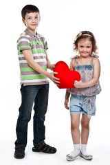 little boy gives a girl a plush heart
