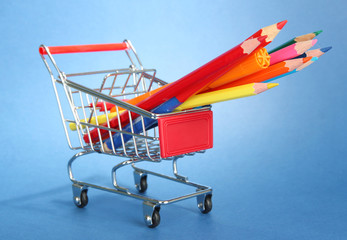 trolley with school equipment on blue background