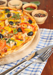 Tasty pizza with kitchen herbs on wooden table close-up