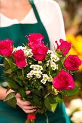 Florist woman holding red roses bouquet hands