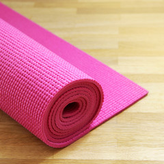 rosa yogamatte auf holzboden