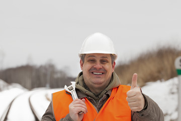 Smiling railroad worker with outstretched hand with thumb up - obrazy, fototapety, plakaty