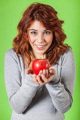 Teenage Girl Holding a Red Apple on Green Background