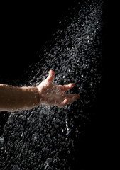 Fototapeta premium hand of baby reach to fresh water droplet from above on black ba