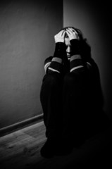 sad woman sitting alone in a empty room - black and white