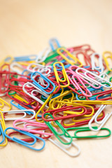 Heap of Paper Clips on Wooden Table