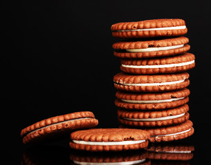 Chocolate cookies with creamy layer isolated on black