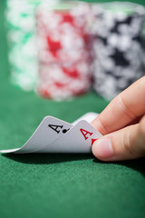 Poker player checking a pair of aces