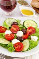 salad on the plate with oil and glass of wine