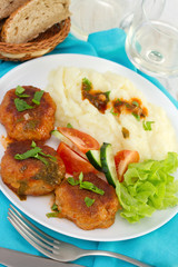meatballs with potato and fresh salad on the plate