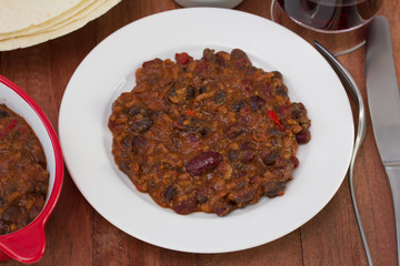 meat with beans and tomato sauce on the plate
