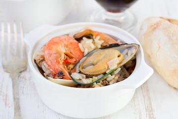 rice with seafood and glass of wine