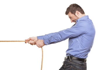 Young man pulling a rope on white background