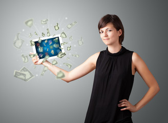 young woman holding tablet with money