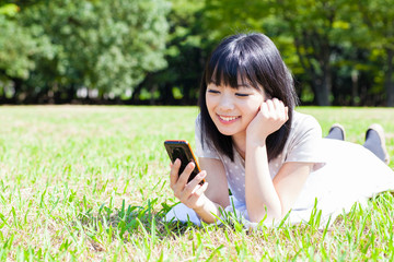 attractive asian woman using smart phone in the park