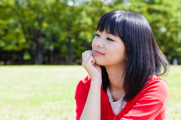attractive asian woman relaxing in the park