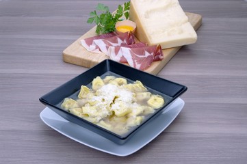 Tortellini in brodo alla bolognese su tavolo in legno