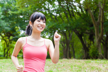 attractive asian woman jogging in the park