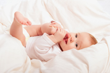 small baby sucking her finger on leg © JenkoAtaman