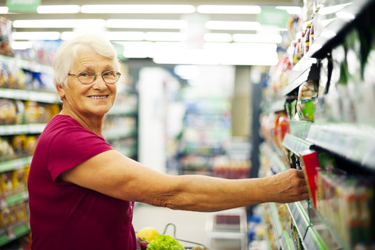 Happy senior woman at supermarket