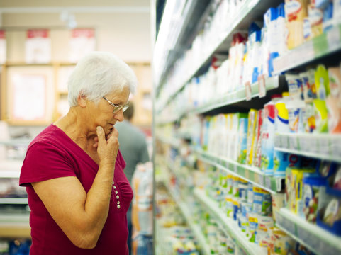 Senior woman choosing a dairy products at supermarket