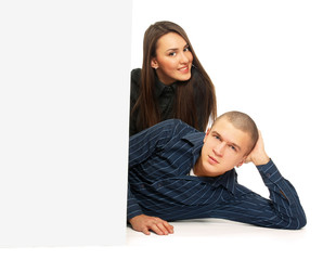 Young man and woman lying near a blank board