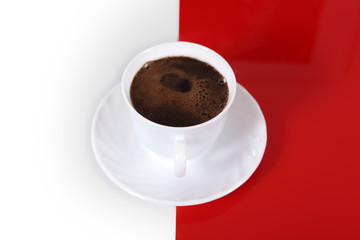 Kawa w białej filiżance na biało czerwonym tle.