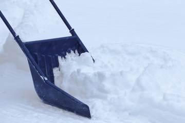 Manual snow removal with snow scoop after blizzard