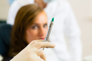 dentist holding a syringe