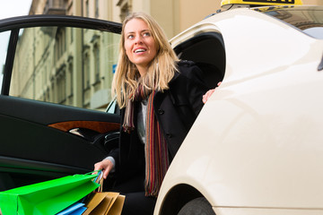 Young woman gets out of taxi