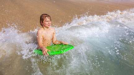boy enjoys surfing at the beach