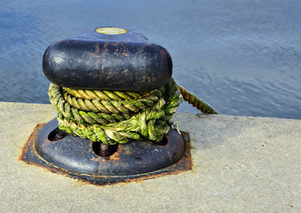 Close-up of mooring bollard with green rope © sergei_fish13