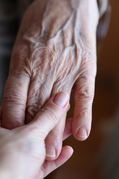 a young and senior hands holding each other