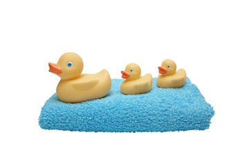 Children's rubber duck with ducklings on blue terry towel isolat