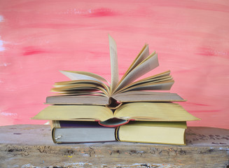 Vintage books arrangement on a old desk, one book open