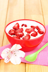 Cottage cheese in red bowl with sliced strawberries