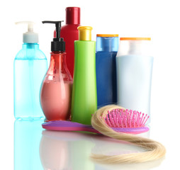 comb brush with hair and cosmetic bottles, isolated on white