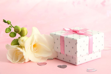 Beautiful romantic gift box and flower on pink background