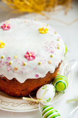 Easter cake with glace icing and easter eggs on white plate
